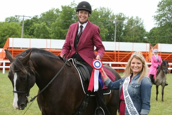 2015 Sutton Fair Ambassador Jenn McCabe presents a first place ribbon to the winner of Mountain Horse English Pleasure class.